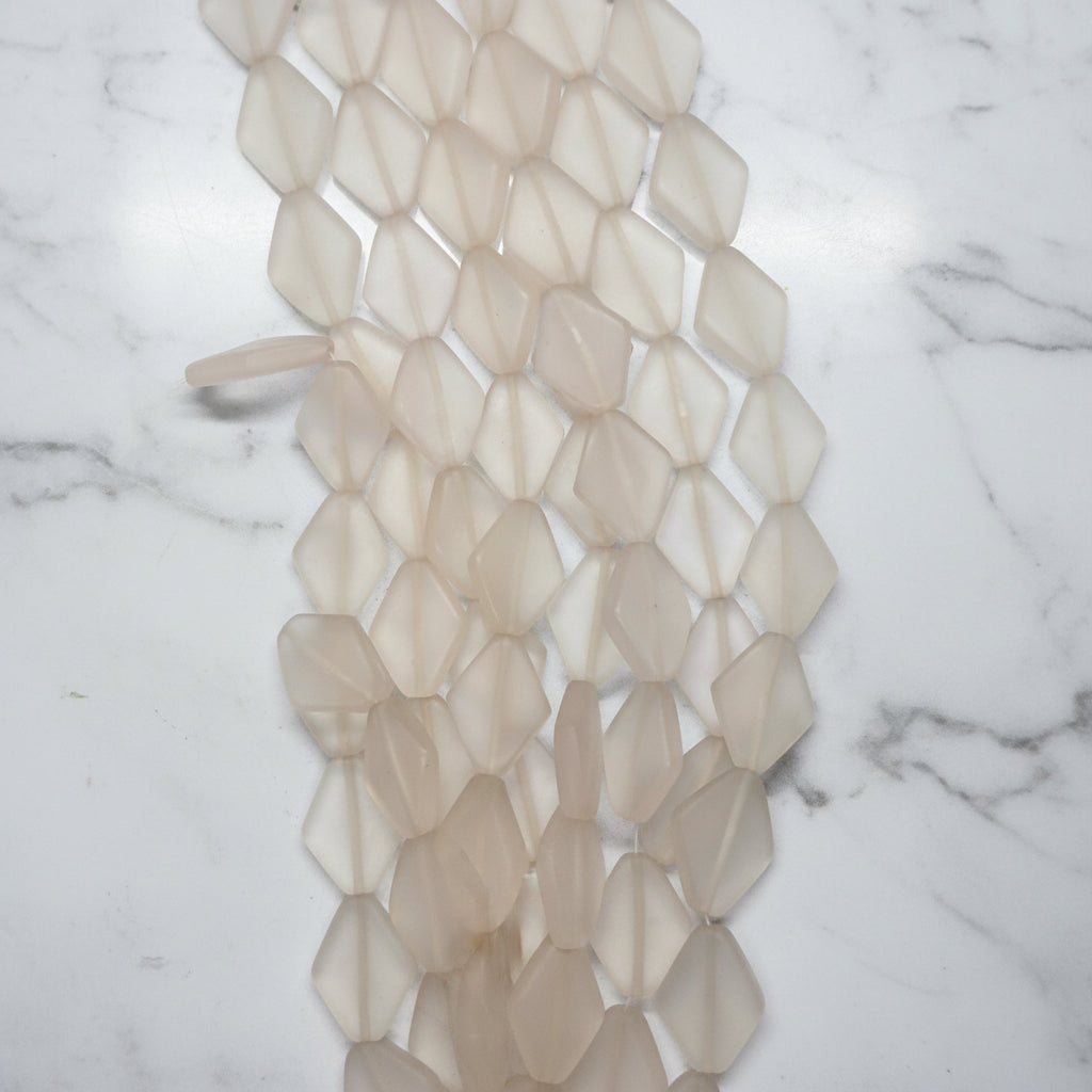 Diamond-shaped resin beads, close-up of clear translucent faceted shapes on strand