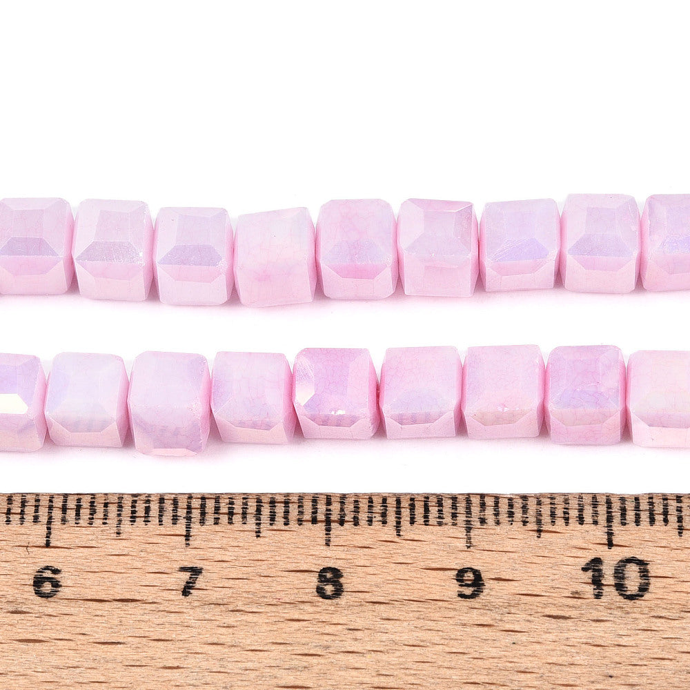 Pink AB faceted cube glass beads strand, size shown against measuring ruler