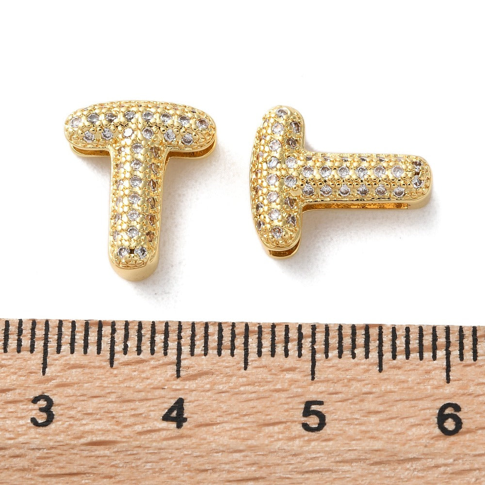 Gold-tone letter T slide charm with pavé cubic zirconia, shown beside ruler for size