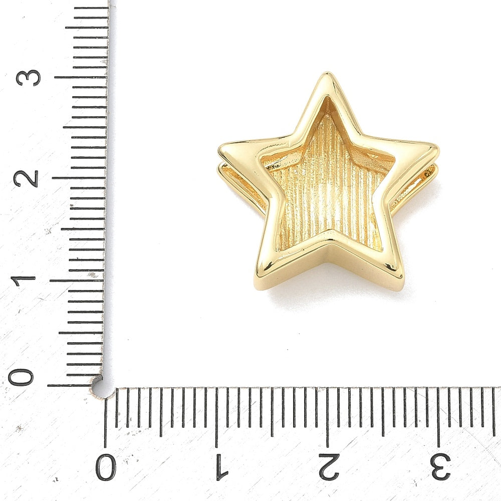 Gold star slide charm next to ruler for size reference