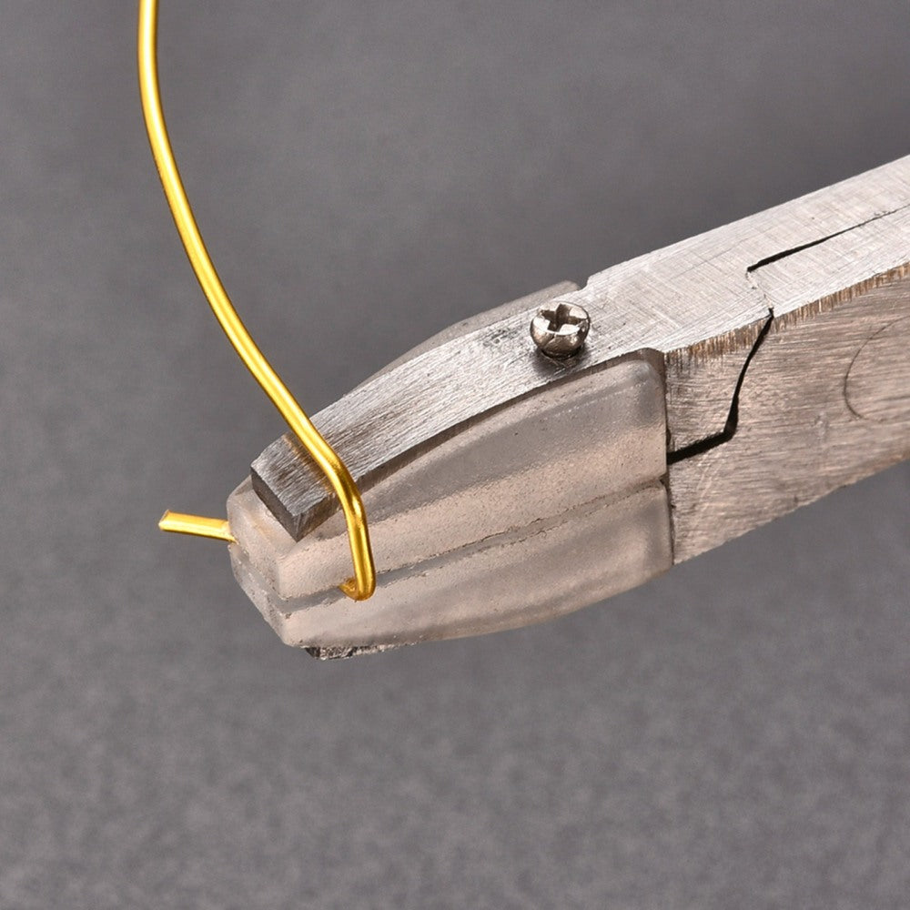 Flat nose pliers holding a yellow wire at the metal jaw tip