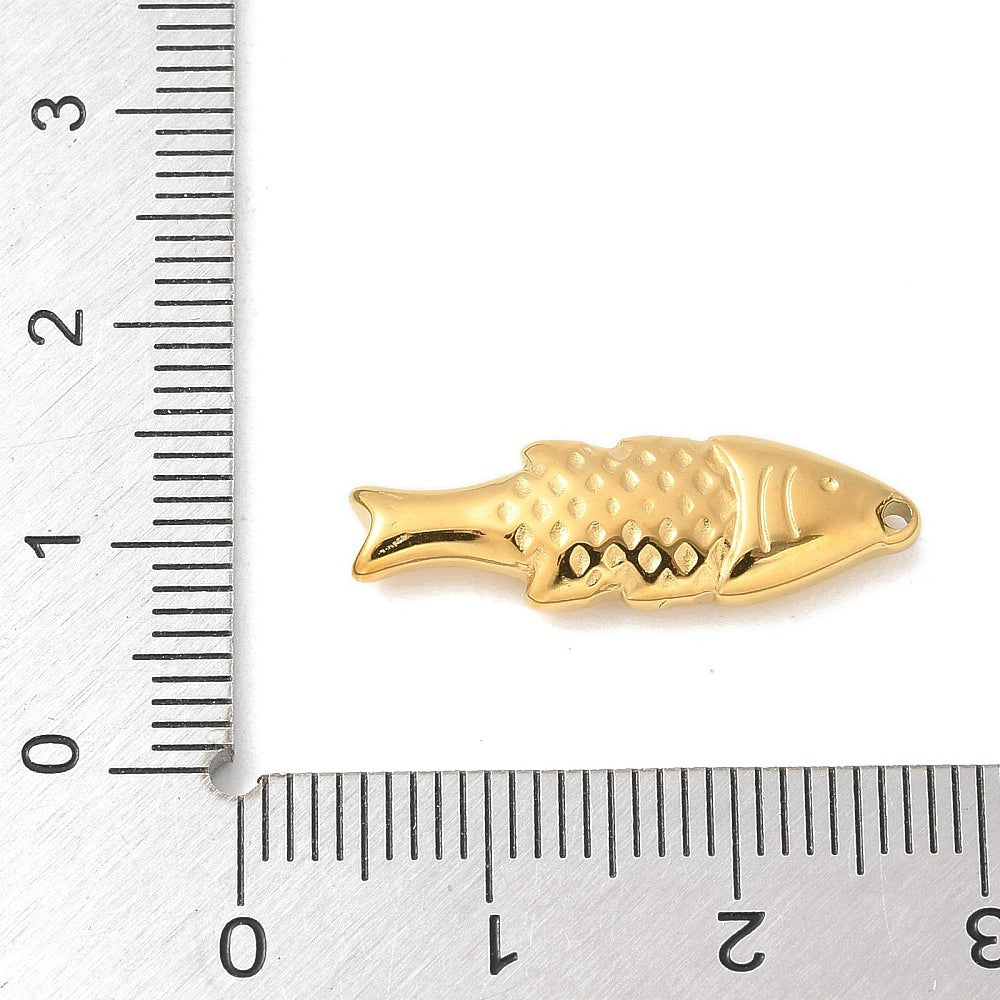 Gold plated fish pendant next to ruler, textured scales and pointed tail