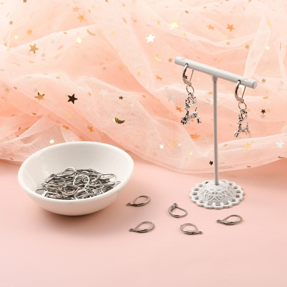 Silver leverback earring findings on a display stand, with loose hooks nearby