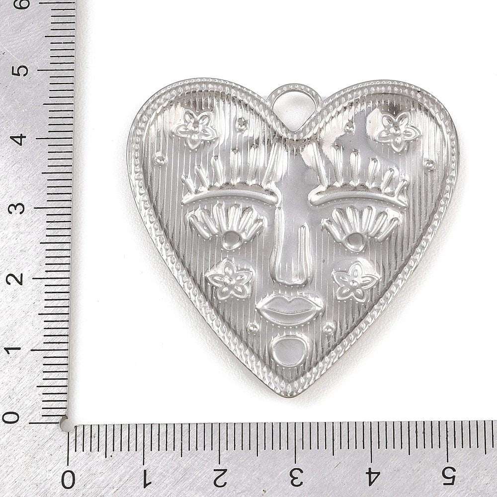 Silver heart pendant with gold-tone details, textured face and top loop