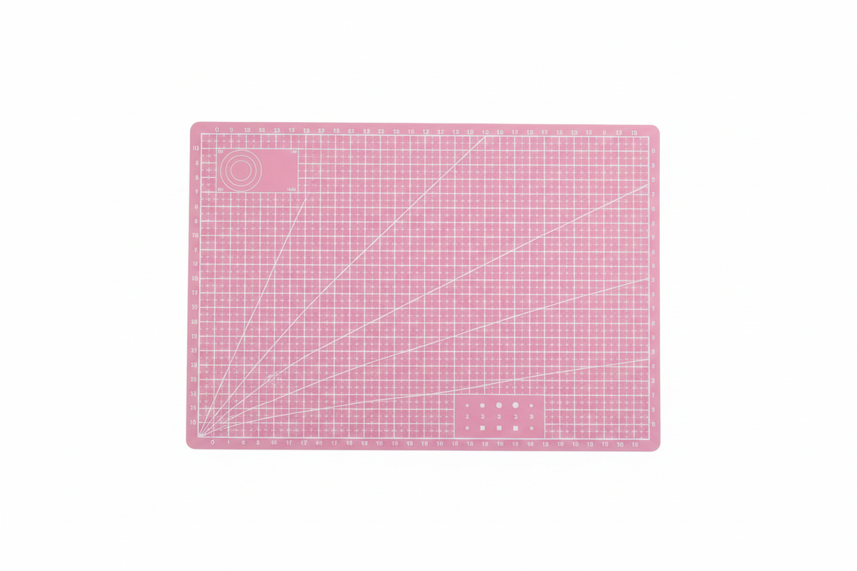 Pink self-healing cutting mat with printed grid and corner guide markings