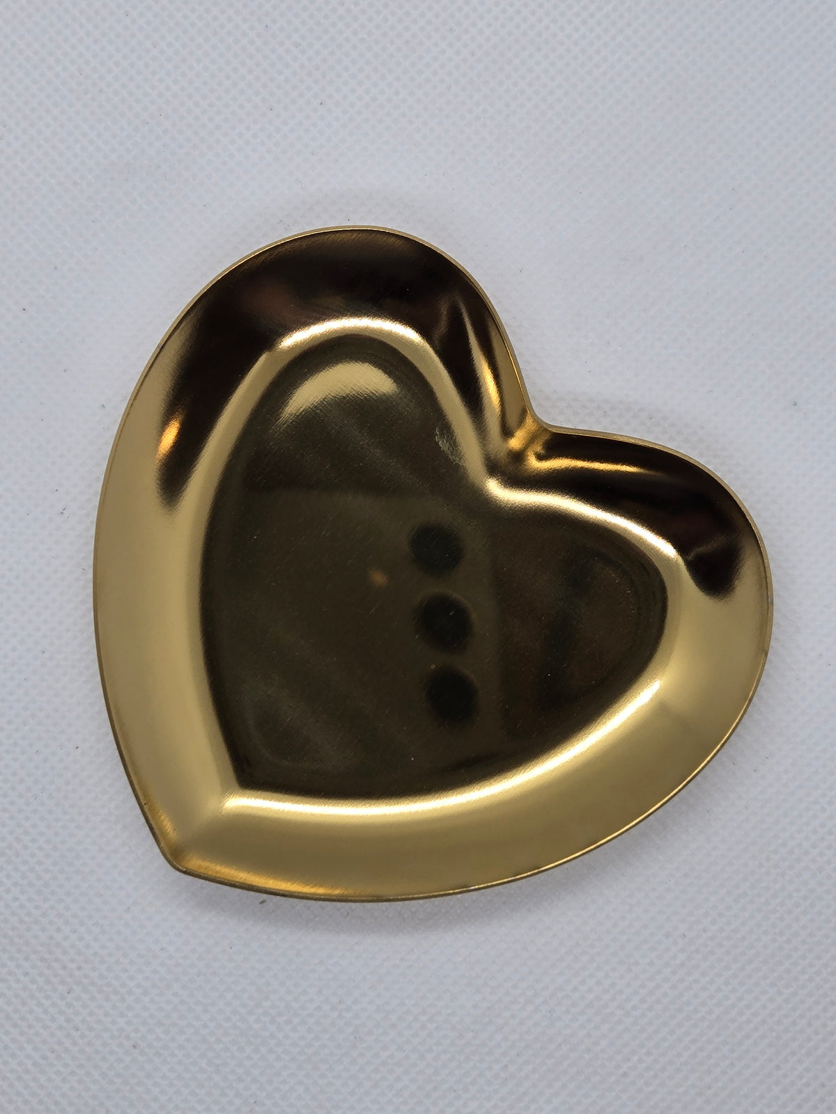 Gold heart-shaped serving plate with raised rim and glossy sheen