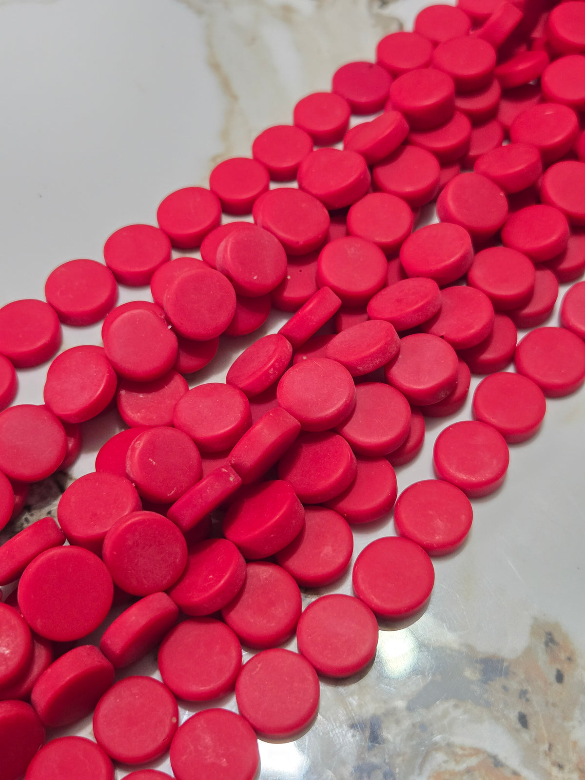 Red flat rondelle resin beads, close-up of glossy discs