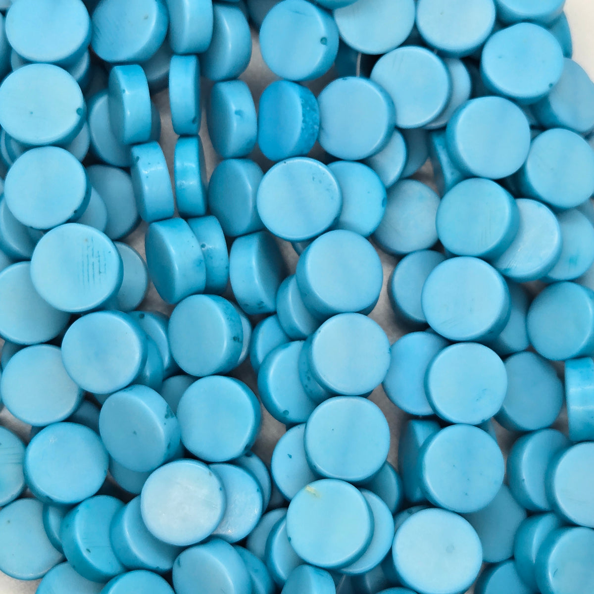 Light blue flat rondelle resin beads strand, close-up of disc beads