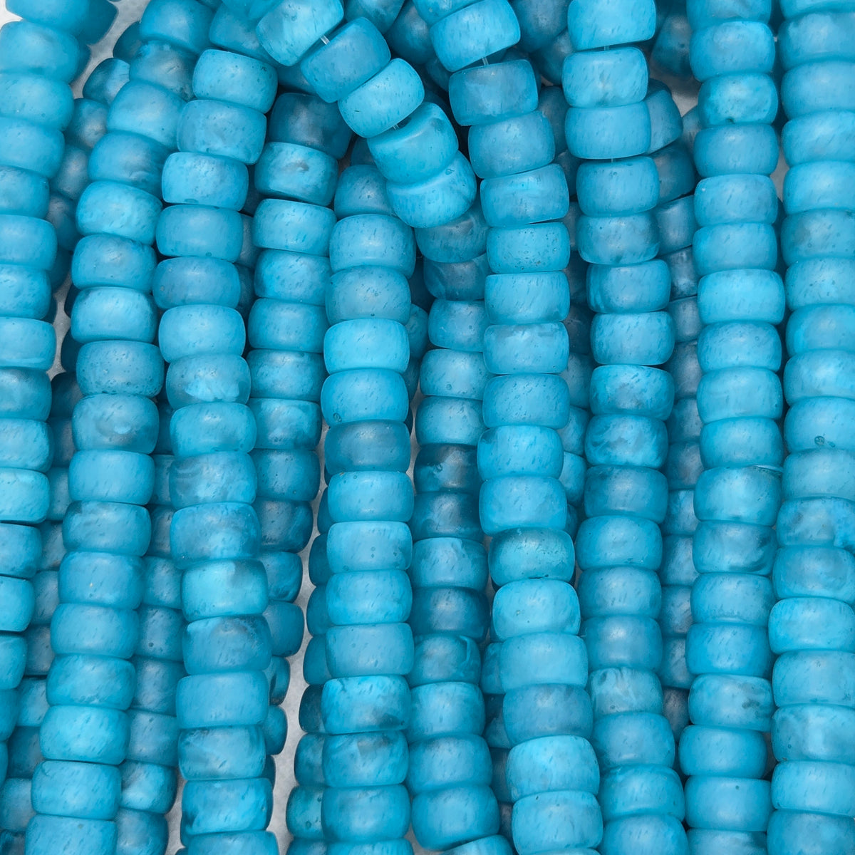 Matte teal rondelle resin beads, close-up of stacked beads