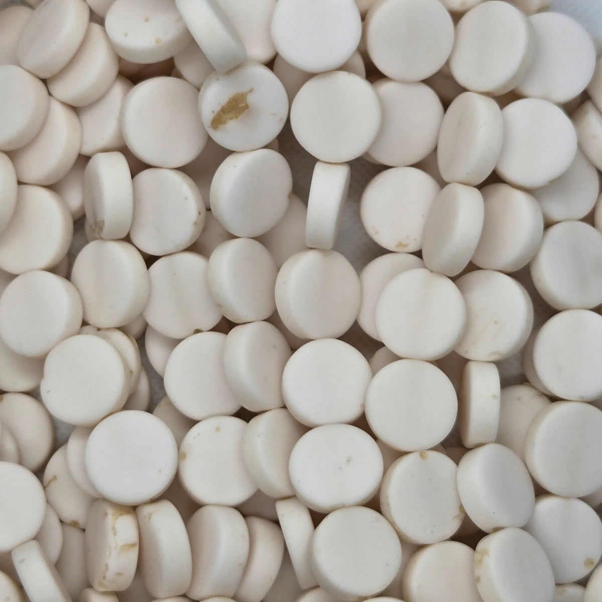 White flat rondelle resin bead close-up strand with smooth round discs.