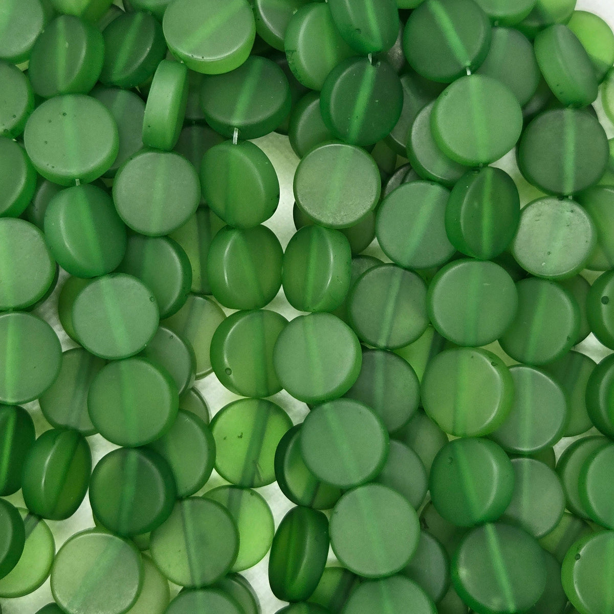 Green flat rondelle resin beads strand, close-up of round flat discs