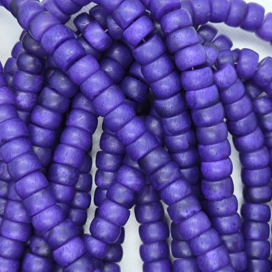 Close-up of purple rondelle resin beads, small rounded discs