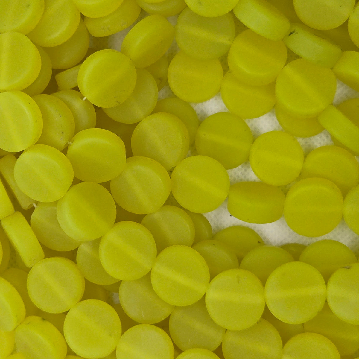 Neon yellow flat rondel resin beads strand, close-up of round disc beads