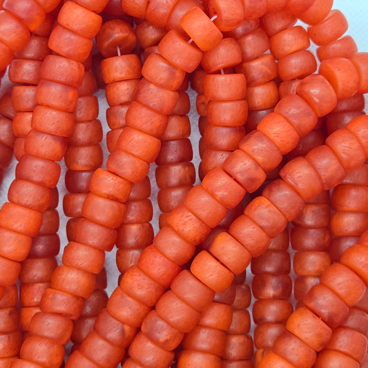 Orange rondelle resin beads on a strand