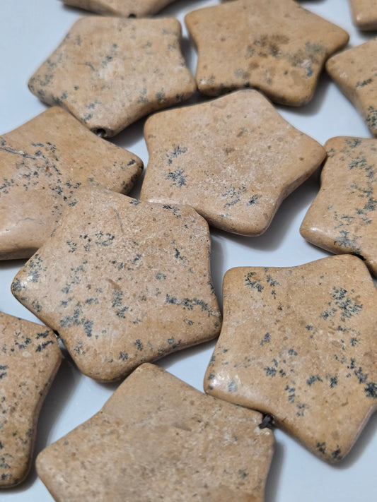 Beige speckled natural stone star-shaped pieces, flat surface