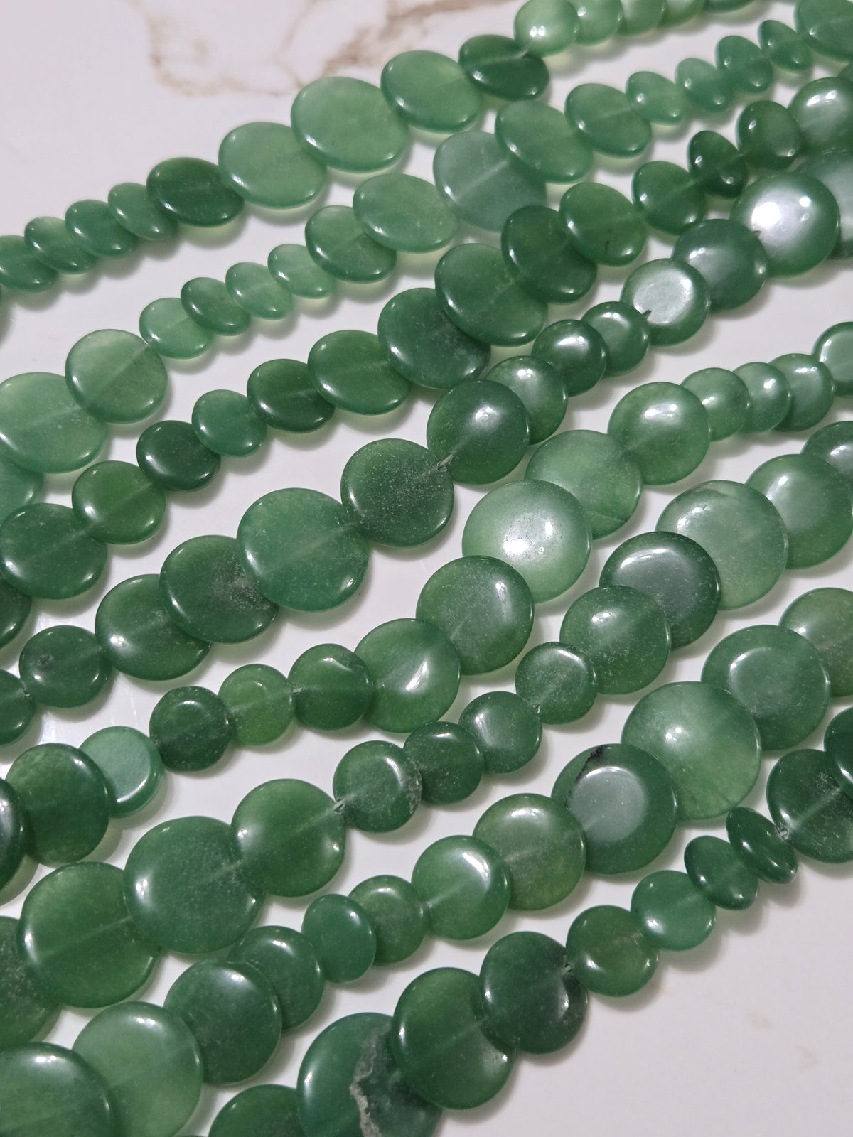 Green jade bead strands with glossy oval and round beads.