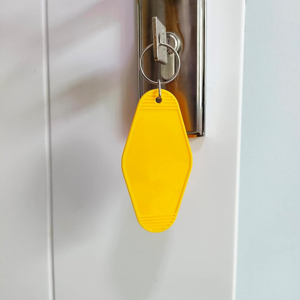 Yellow blank hotel keychain tag with metal split ring and small hanging loop