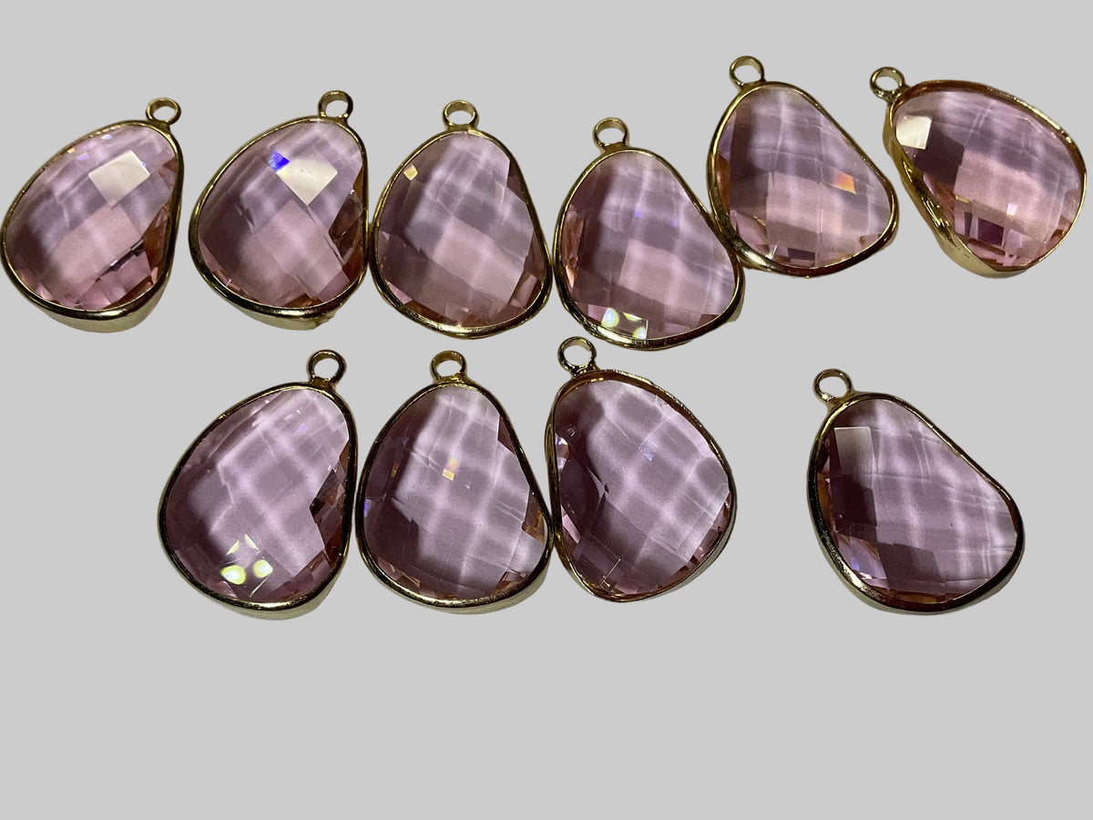 Faceted teardrop crystal pendants with pink tones and gold-tone loops