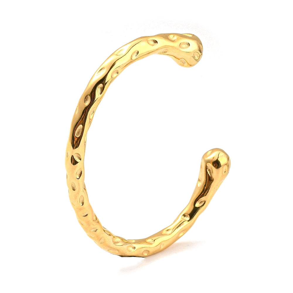 Gold-tone cuff bangle with raised oval pattern and small circular rivets, open style