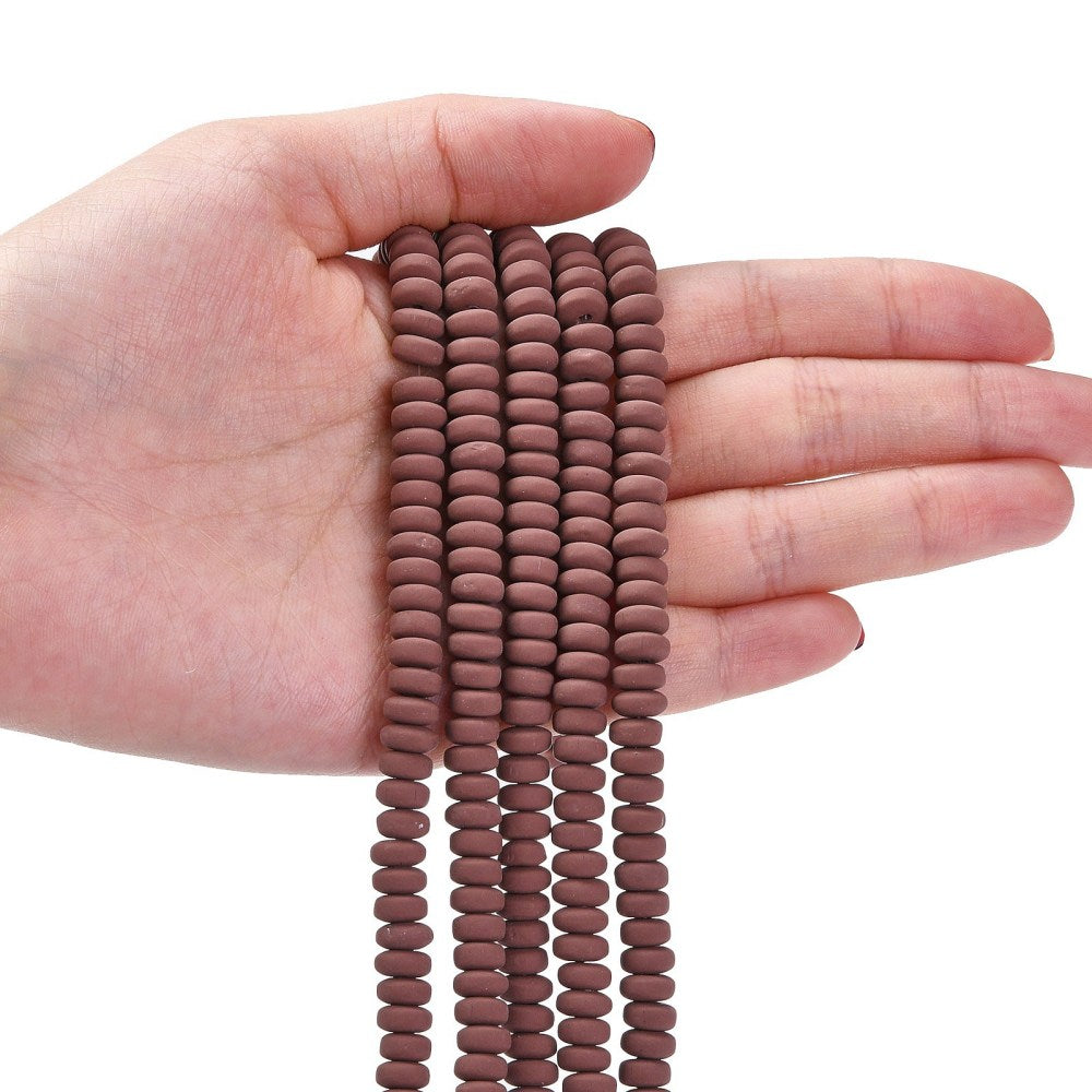 Saddle brown flat round polymer clay bead strand held in hand