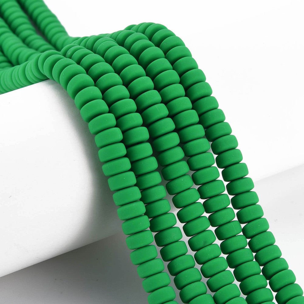 Green flat round polymer clay bead strand, closely packed ridged discs, close-up
