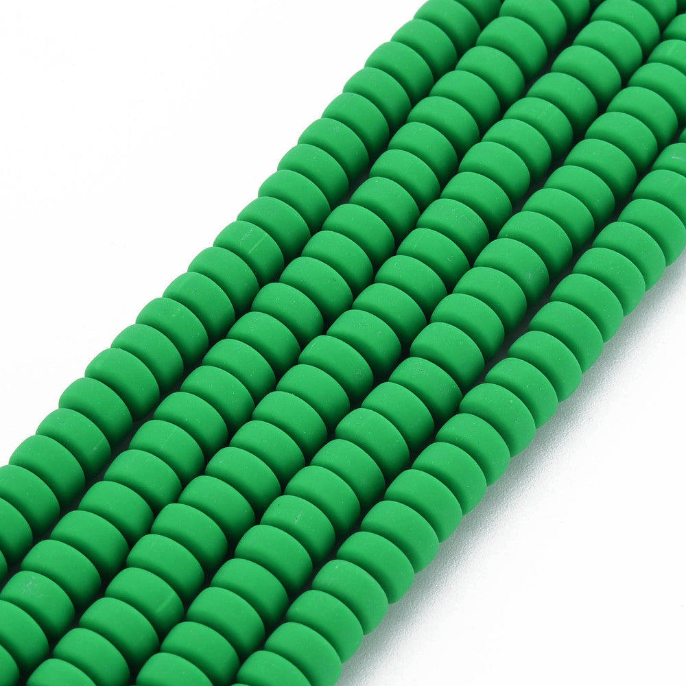 Green flat round bead strand with tightly strung discs, coiled on white