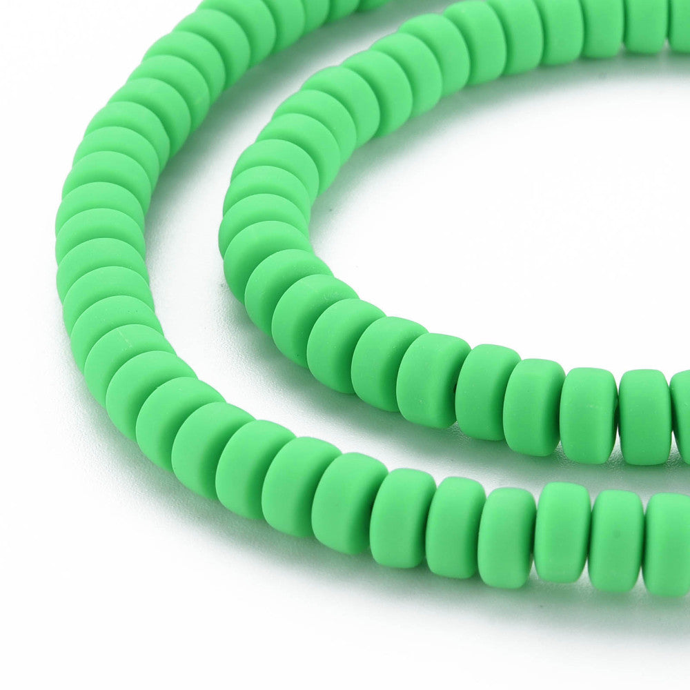 Lime green flat round polymer clay beads strand, edge-on view of smooth layered discs