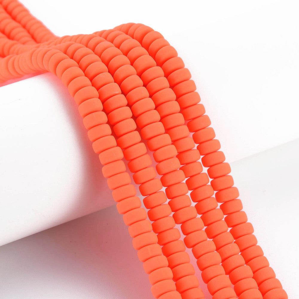 Orange-red flat round polymer clay bead strand, ridged discs, close-up