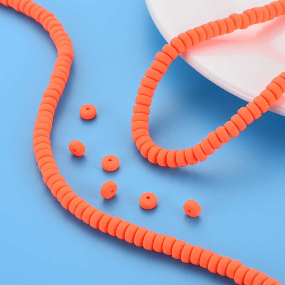 Orange-red flat round polymer clay bead strand with several loose beads