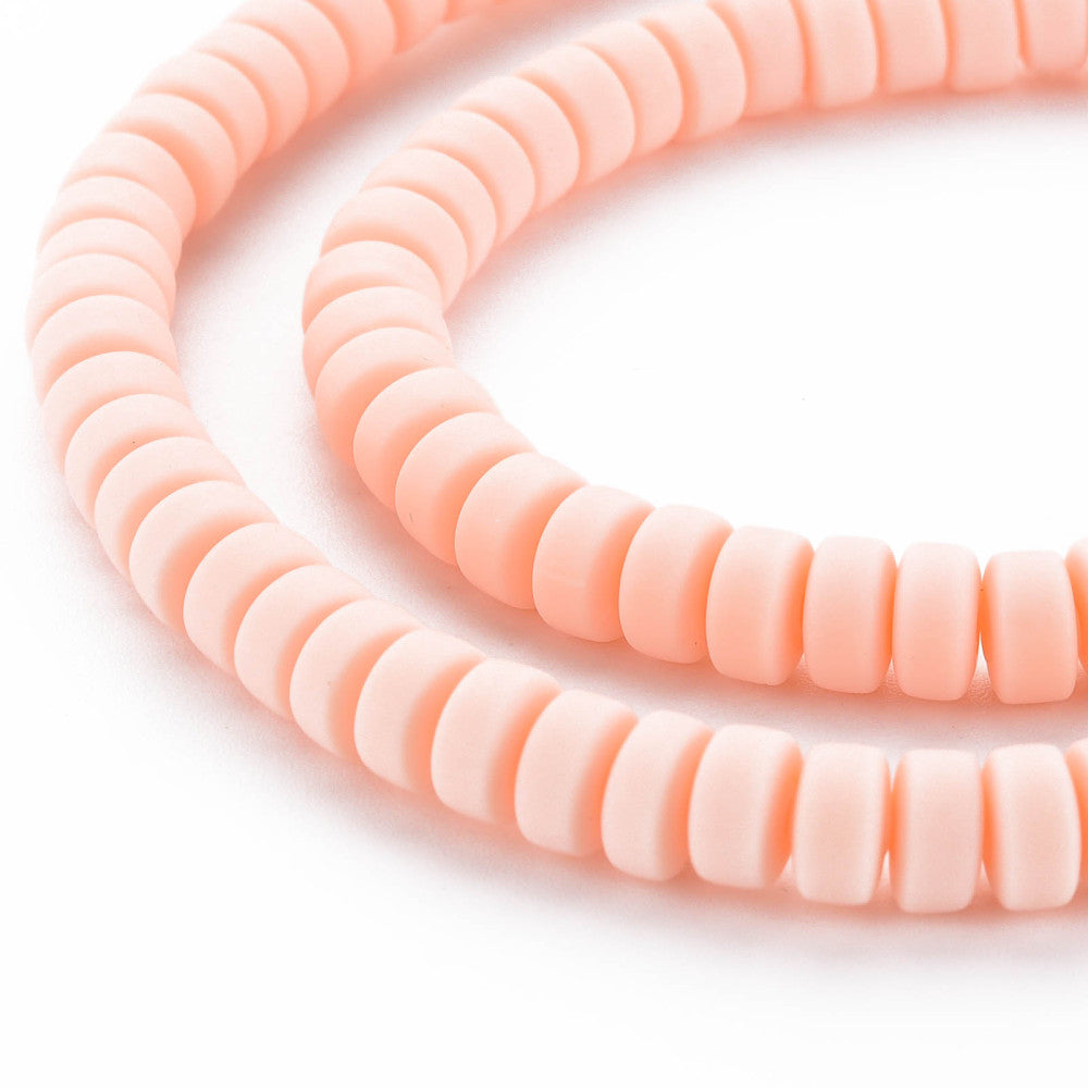 Flat round bead strands close-up, pale pink ridged discs