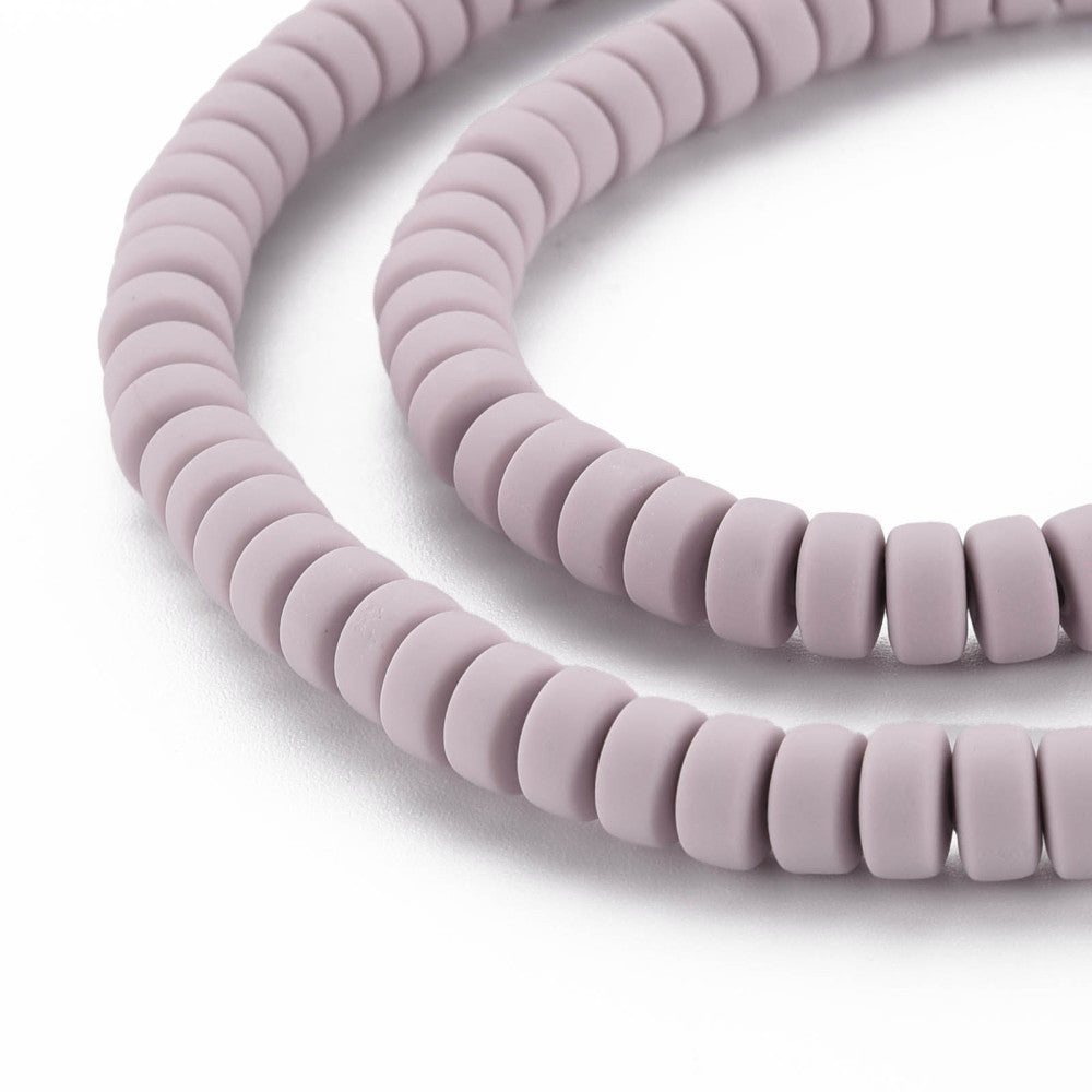 Polymer clay bead strand close-up showing flat round lavender-pink beads
