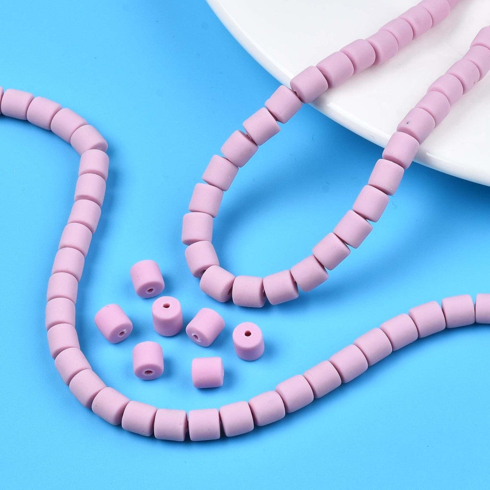 Light purple column beads and loose beads with central holes on a plate