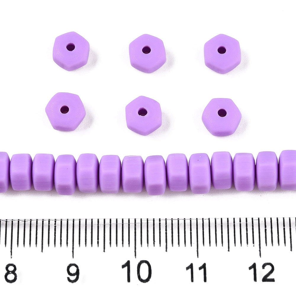 Purple hexagon polymer clay beads with holes; size shown next to a ruler (approx.)