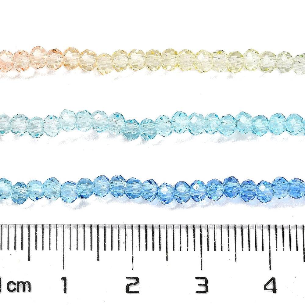 Transparent faceted glass rondelle beads rows with ruler, peach, pale green, aqua, and blue.