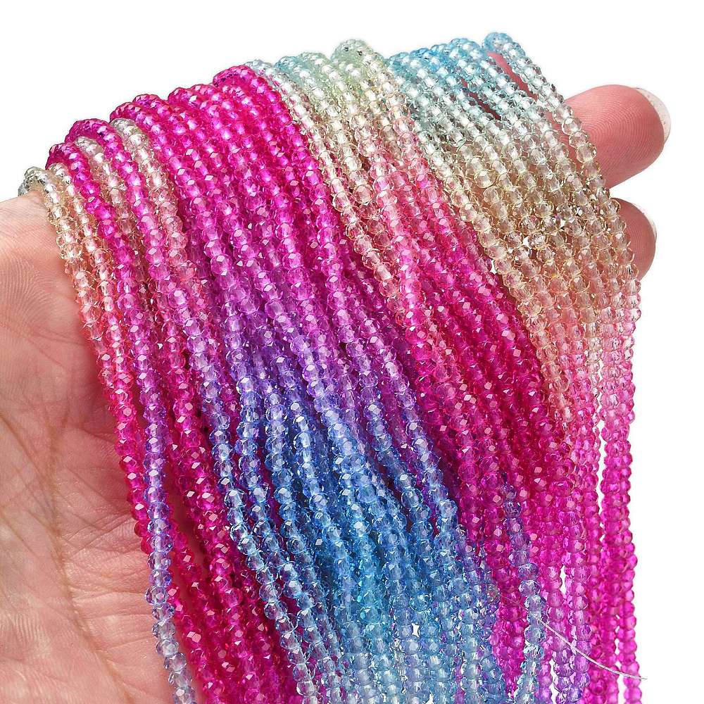 Handheld faceted glass rondelle bead strands in bright pink, blue, and clear tones