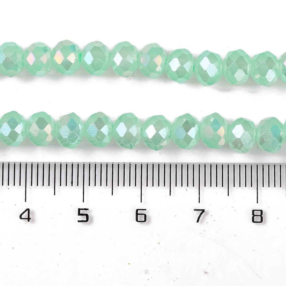 Faceted aquamarine glass rondelle bead strand with AB finish, shown with ruler scale