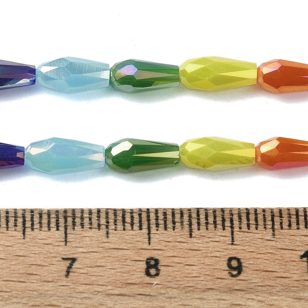 Faceted teardrop glass beads strand with mixed colors, measured against a ruler for scale