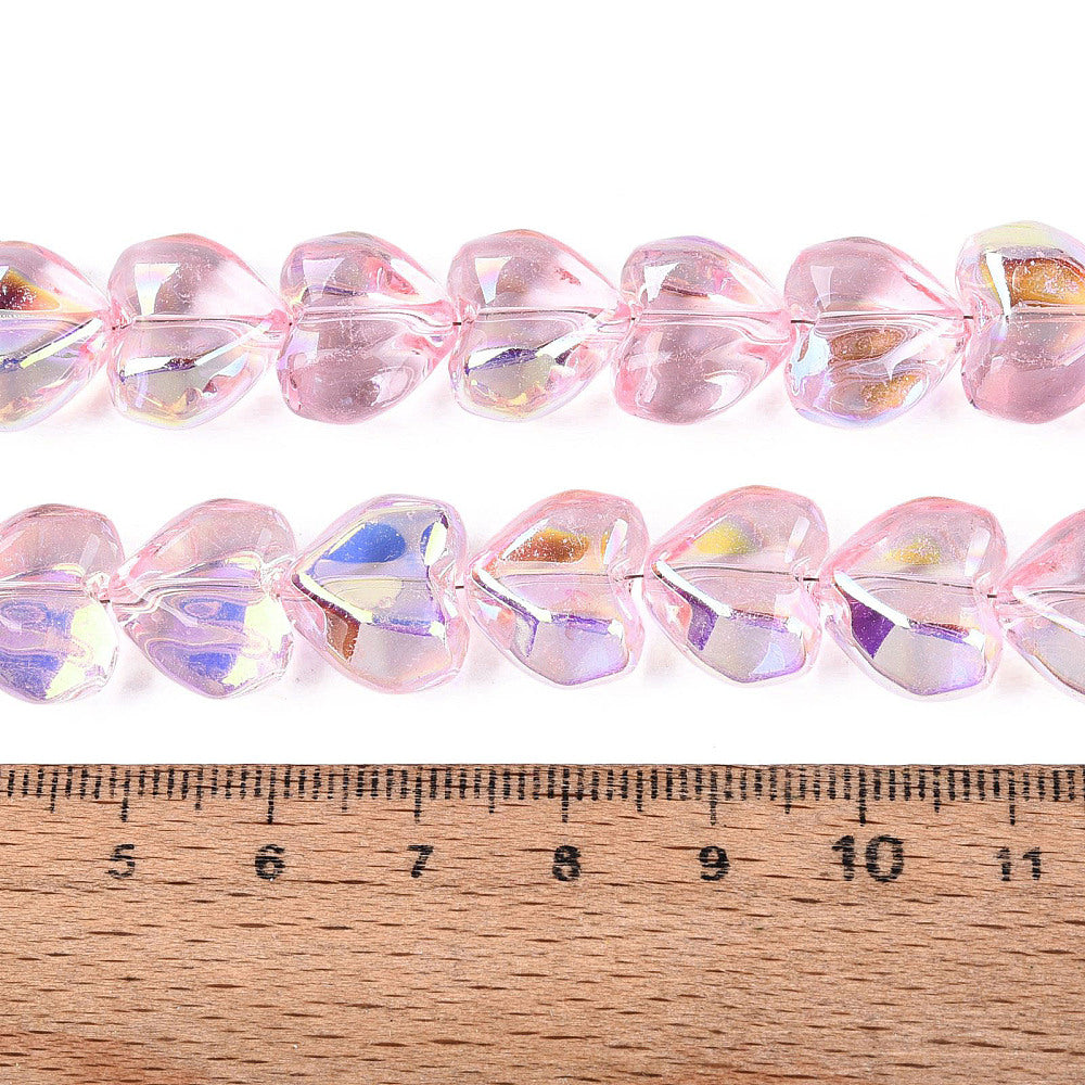 Pink heart glass beads with AB shimmer, faceted; ~12–13mm shown against ruler