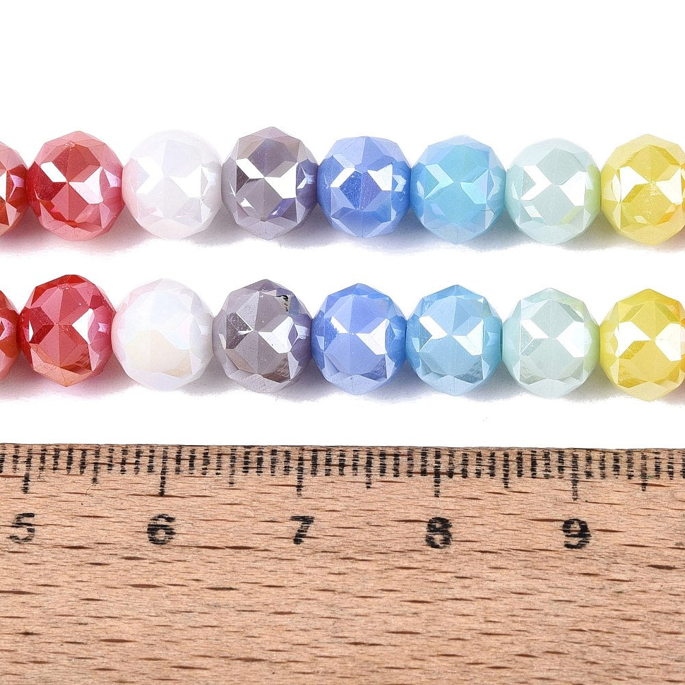 Faceted round glass beads strand with mixed colors, sized beside a wooden measuring rule