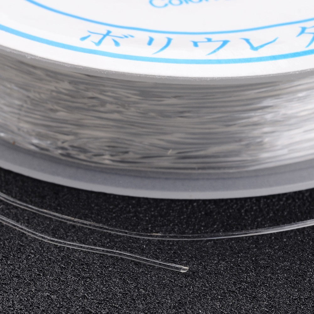 Clear elastic crystal thread strands close-up on spool edge