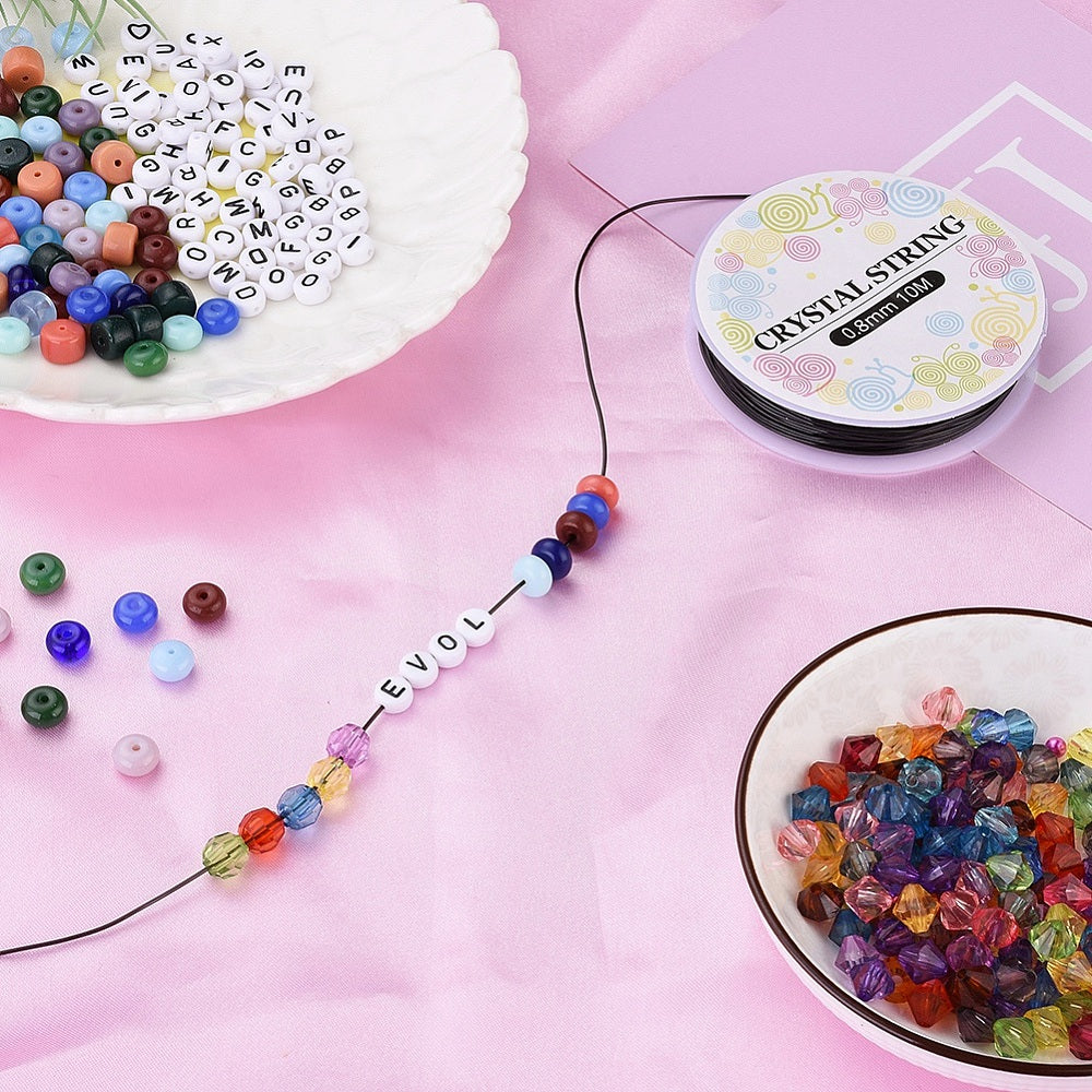 Elastic beading cord threaded with colorful beads, alongside a black string reel.