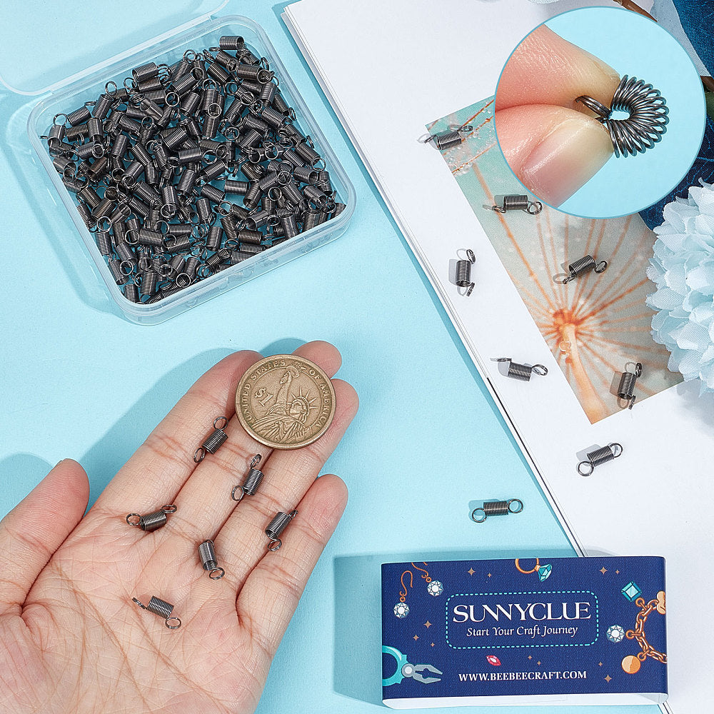 Gunmetal spring bead clamp pieces held in a hand for jewelry making