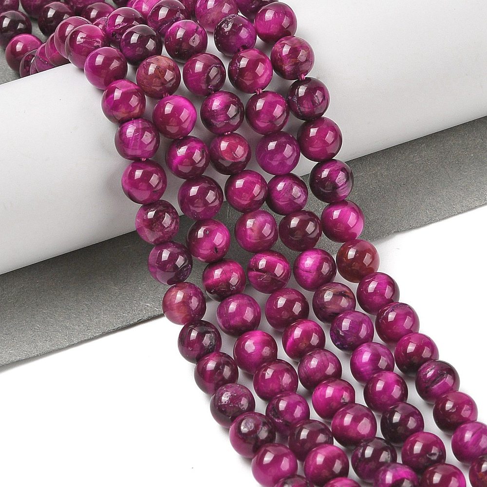 Dyed purple round beads strand draped in loops, smooth glossy bead surfaces