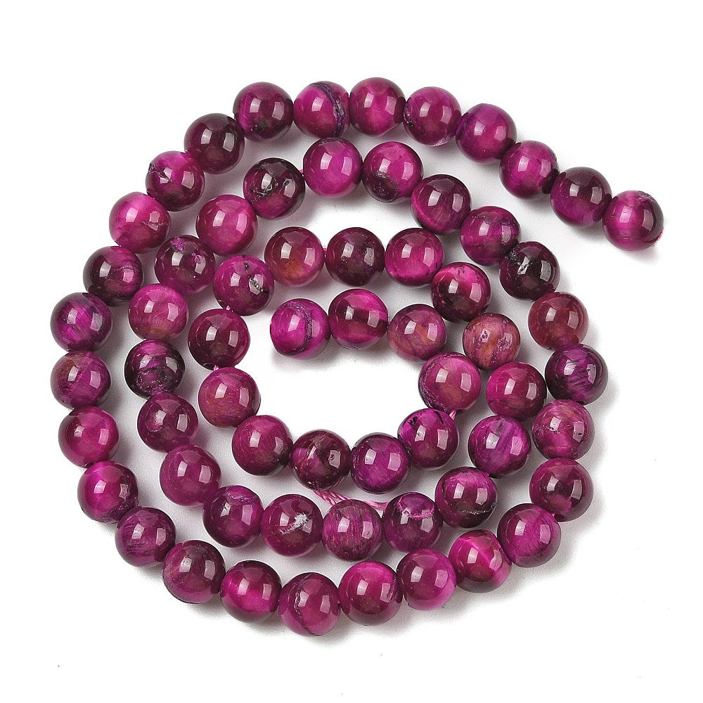 Dyed purple round beads strand, evenly sized glossy spheres laid out flat