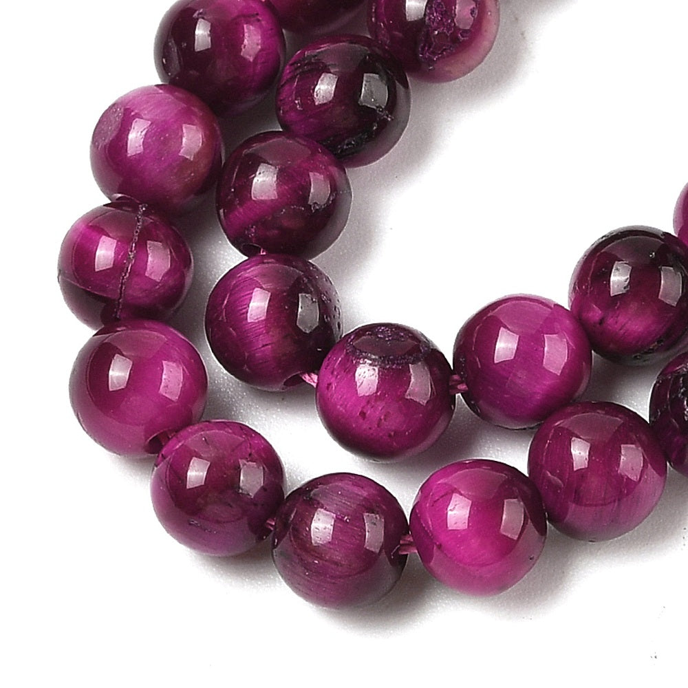 Close-up of dyed purple round beads with glossy reflections and smooth round shape
