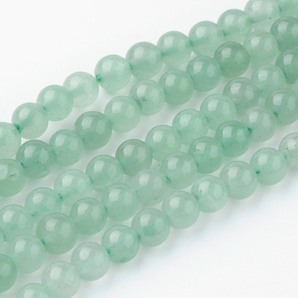 Green round gemstone beads strand with glossy faceted surface, close-up view