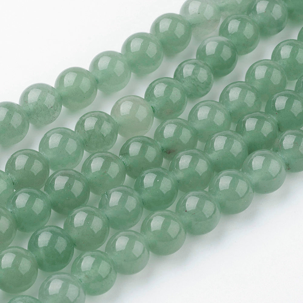 Green round gemstone beads strand with glossy facets, angled close-up