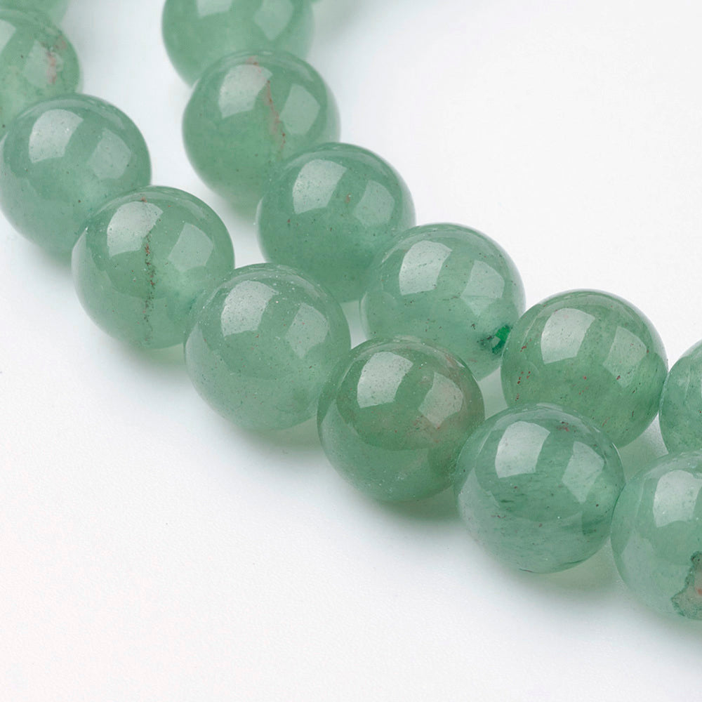 Close-up of green round gemstone beads with glossy finish and facets