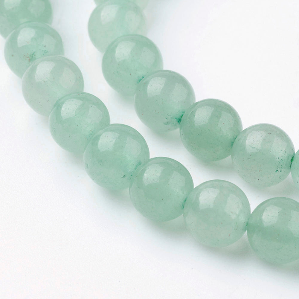 Two strands of green round gemstone beads laid parallel, glossy faceted beads