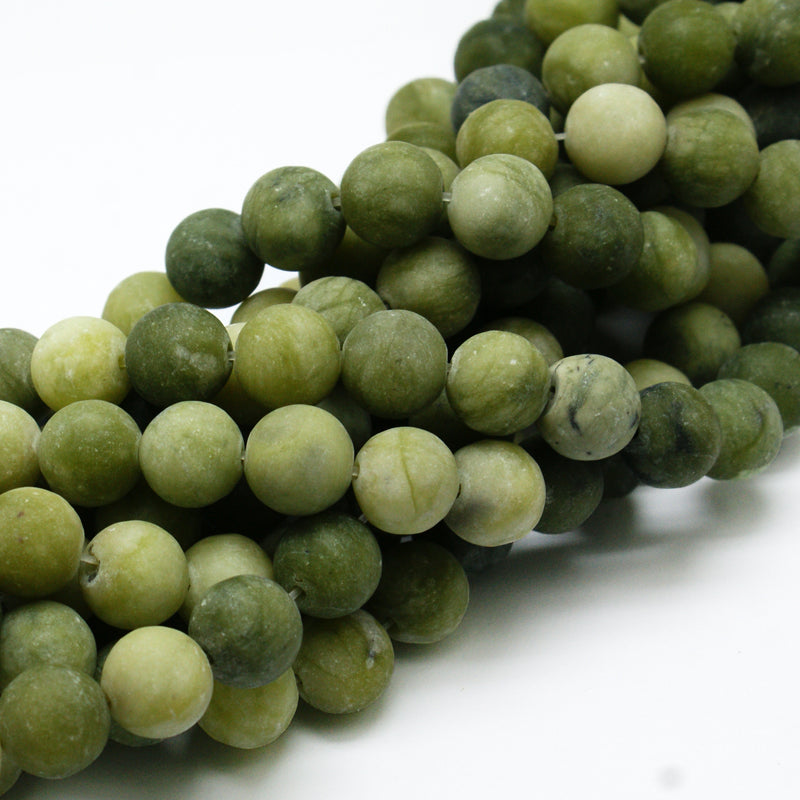 Green round jade beads, matte frosted surface, mixed tones in a pile